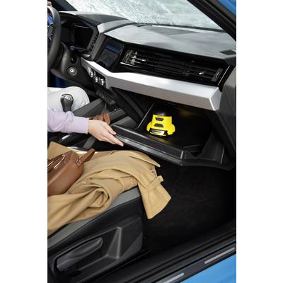 Una persona apre il vano portaoggetti di un'auto e afferra un oggetto giallo al suo interno. Un cappotto è adagiato sul sedile.
