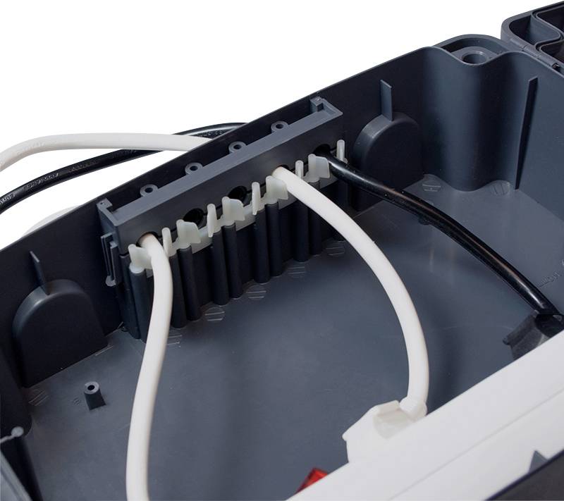 Scatola di connessione elettrica con più cavi collegati attraverso aperture, che mostra un metodo di cablaggio e installazione ordinato.