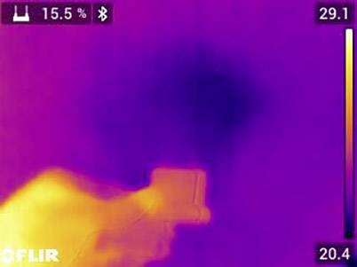Immagine termica mostra una mano con una fotocamera. Temperatura scala da 20,4 a 29,1 gradi Celsius. Nell'angolo in alto a sinistra è visibile l'indicatore della batteria.