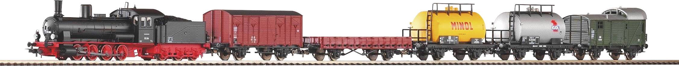 Un trenino con locomotiva a vapore nera, vagone merci rosso, vagone cisterna giallo e carro cisterna grigio sui binari.