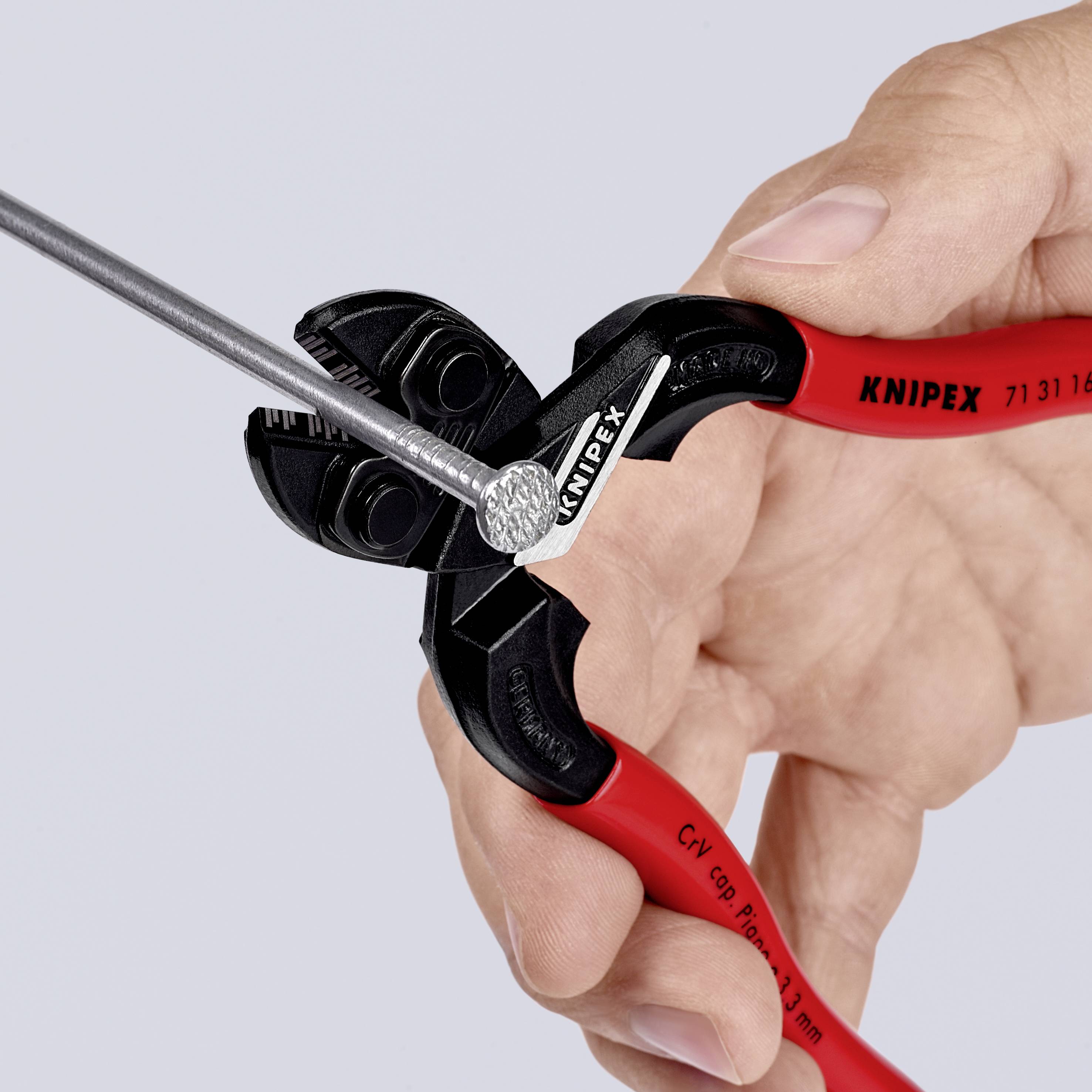 Una mano tiene una pinza rossa KNIPEX che taglia un cavo d'acciaio argentato. La pinza è contrassegnata con il marchio 'KNIPEX' e il numero di modello.