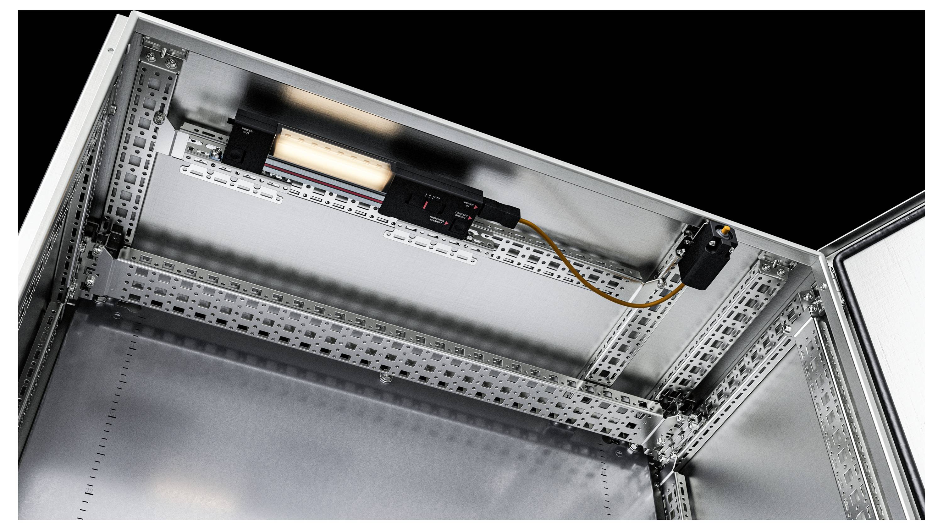 Un quadro elettrico aperto mostra un'illuminazione installata nella parte superiore, circondato da strutture metalliche e cablaggio.