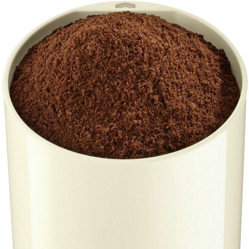 Un contenitore aperto, bianco, riempito di caffè macinato, mostra un mucchio di polvere di caffè marrone.