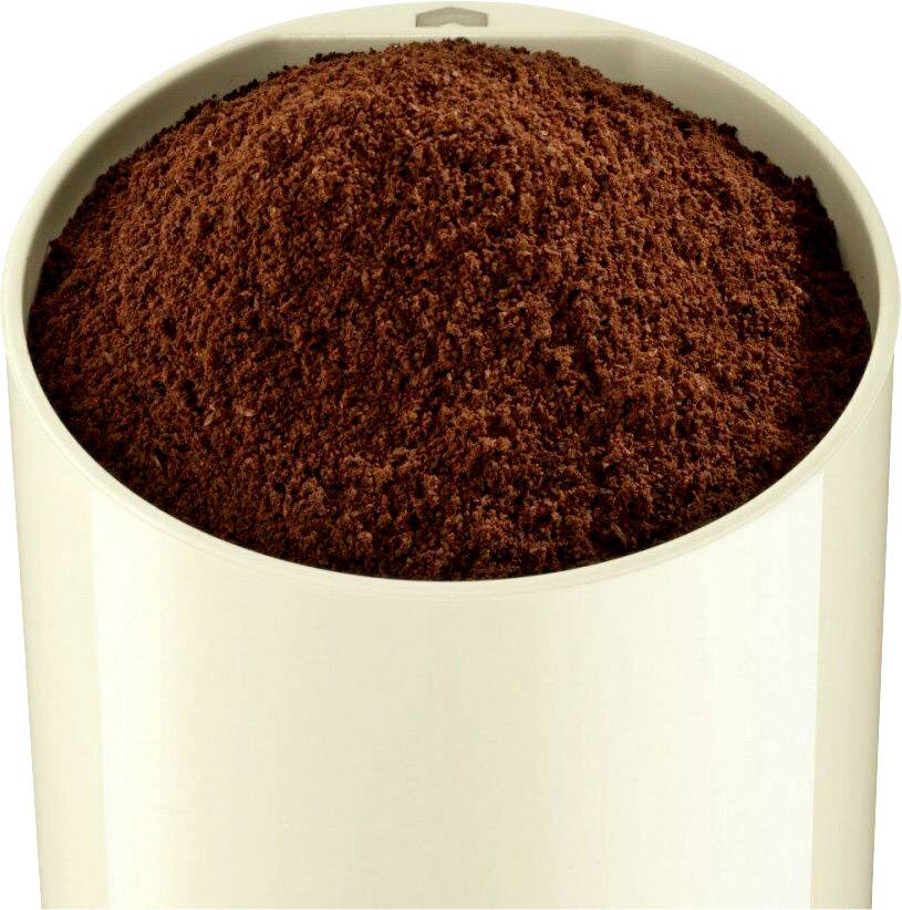 Un contenitore bianco è riempito con polvere di caffè marrone.