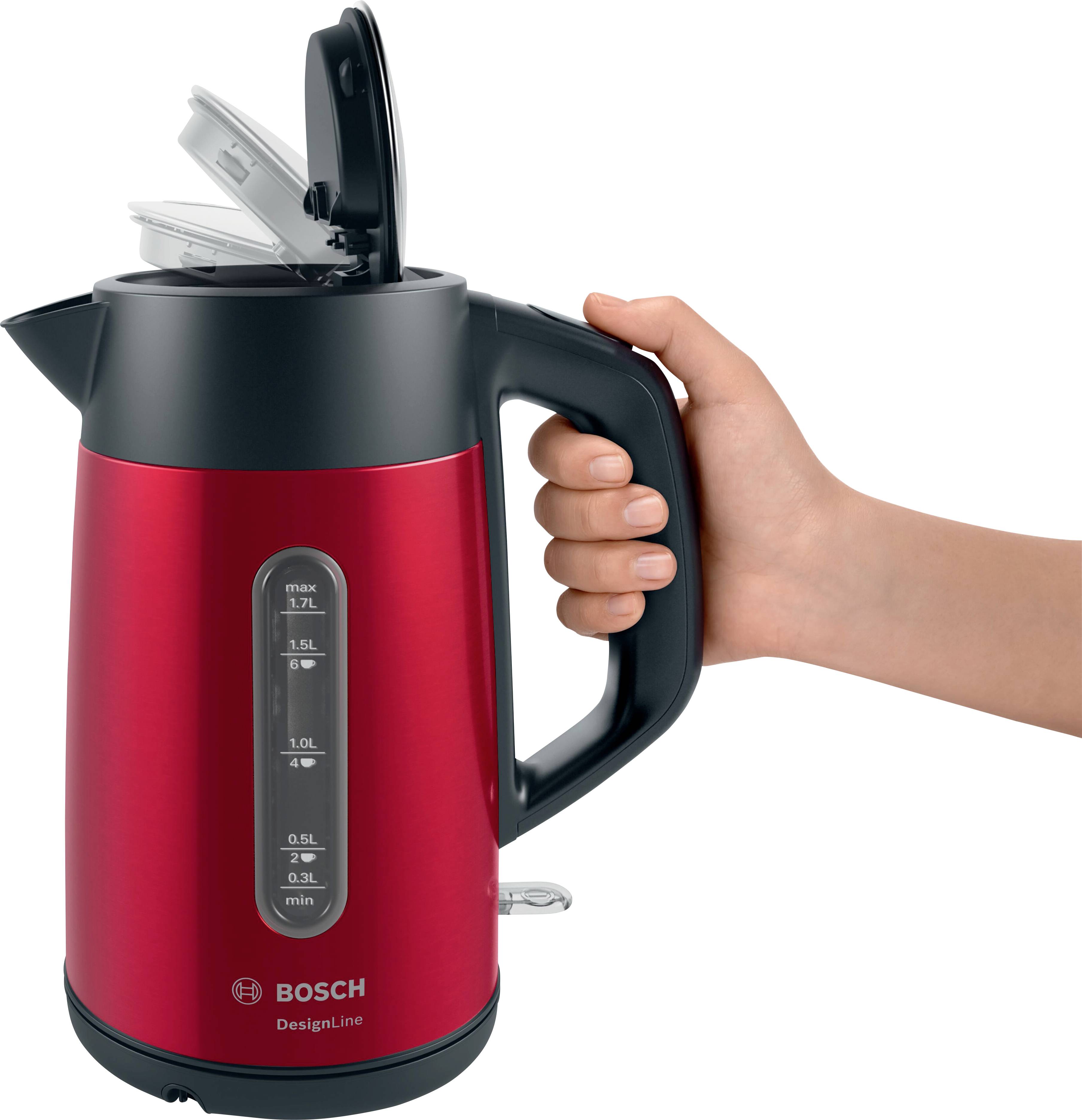 Una mano tiene un bollitore rosso con manico nero. Il bollitore ha una finestra trasparente con indicatore del livello dell'acqua.