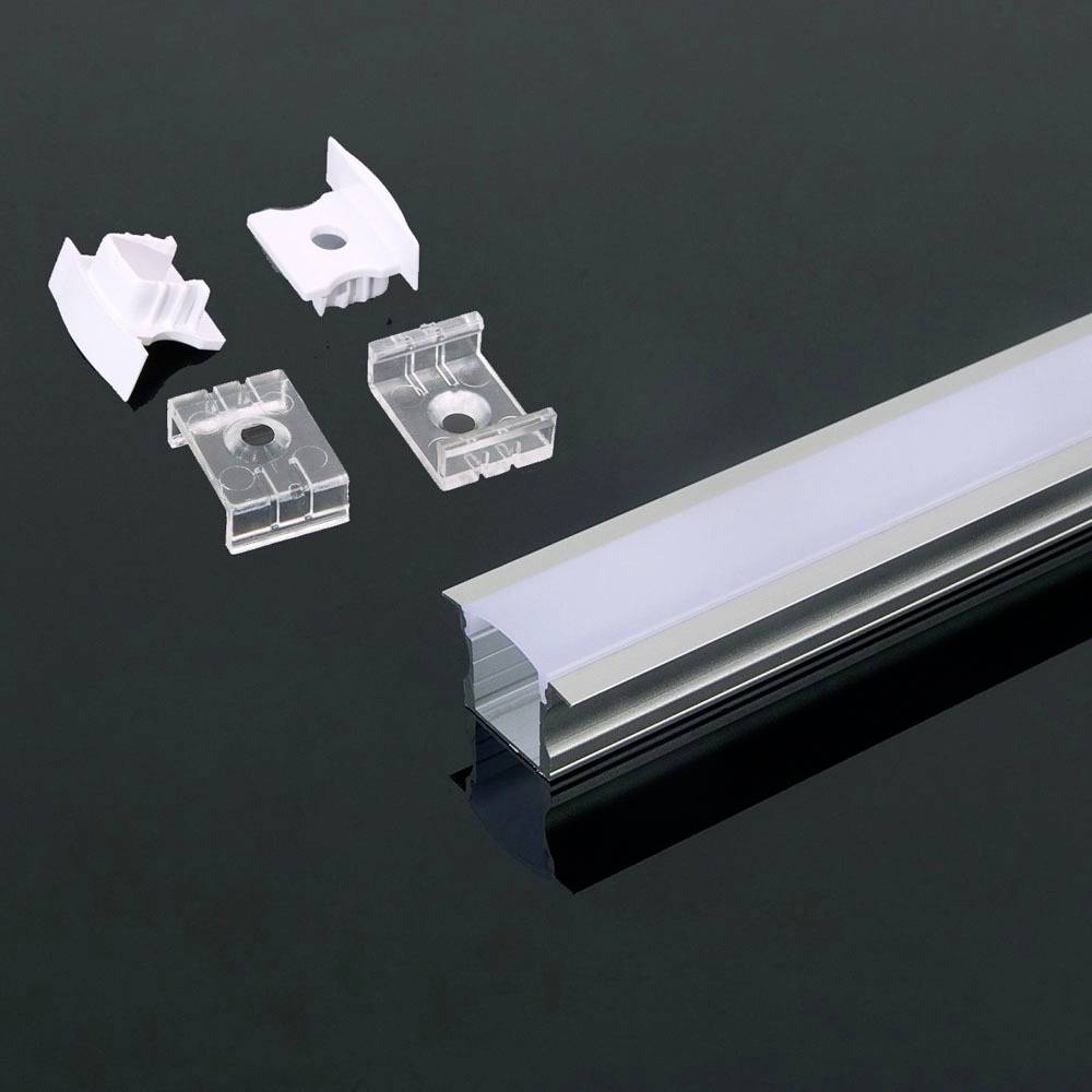 Un kit di profilo in alluminio per LED con una lunga guida a destra e quattro clip di montaggio a sinistra, su uno sfondo scuro.