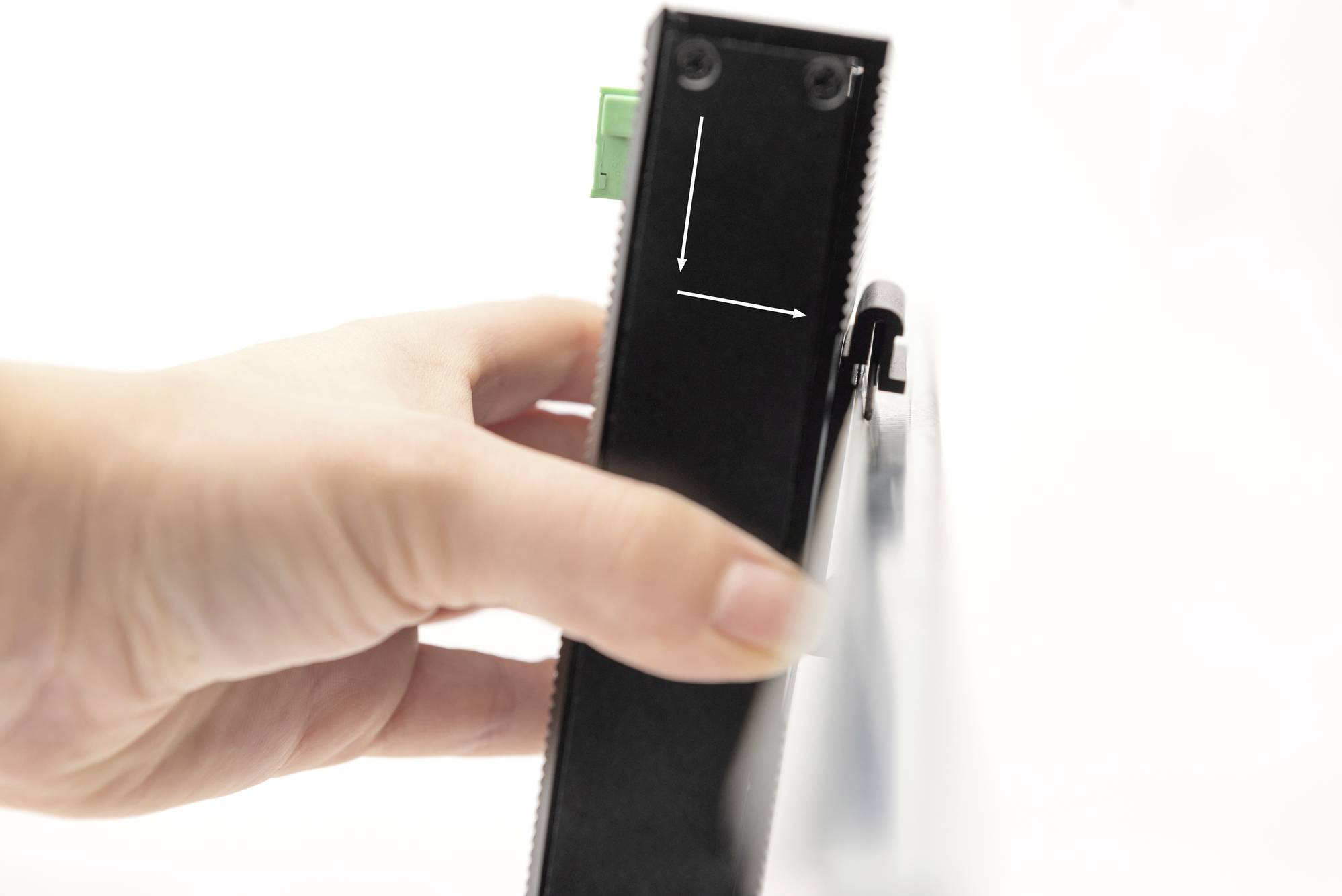 Una mano regge un dispositivo nero rettangolare che mostra una linea incisa a lato, formante un angolo retto.