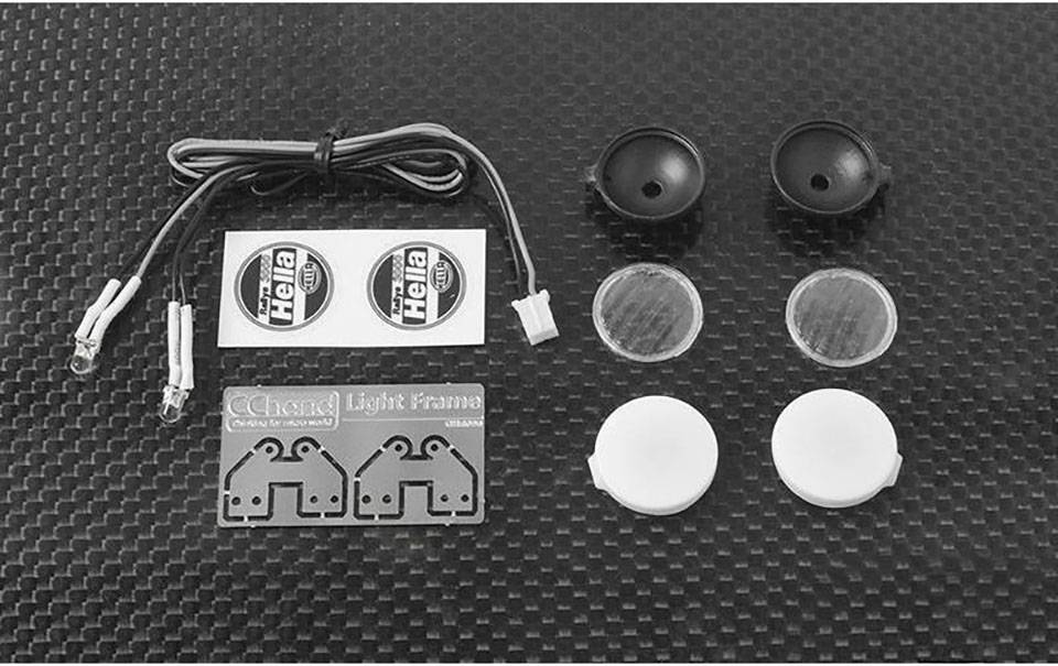 Impostare un set di componenti Auto-Lichtteilen, composto da cavi, adesivi, coperture e un telaio metallico su uno sfondo nero in carbonio.