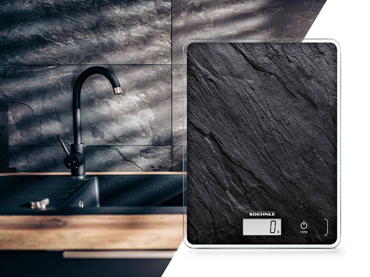 Una bilancia digitale da cucina con finitura effetto ardesia accanto a un rubinetto nero su un bancone da cucina. Il display mostra '0'.