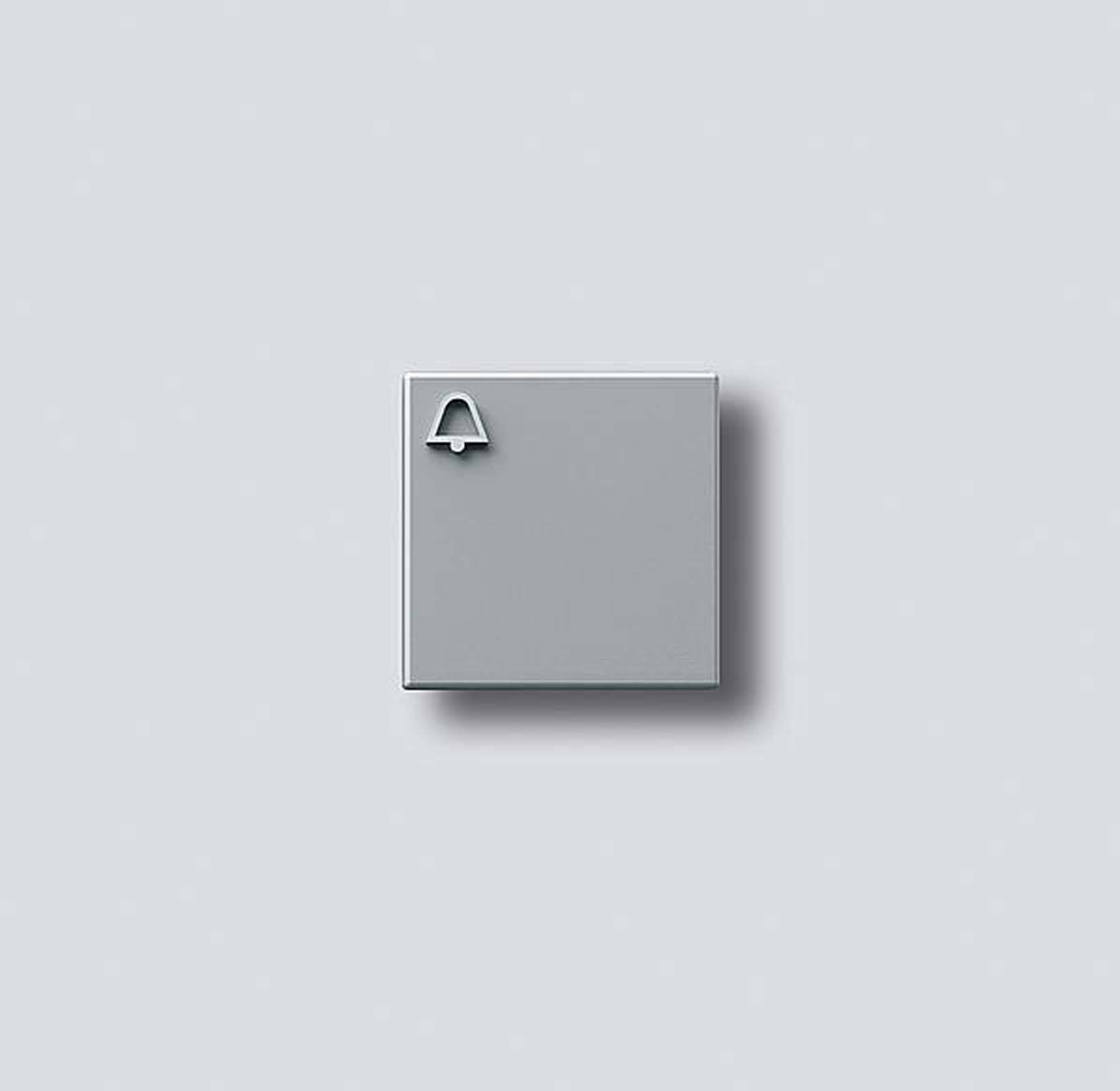 Campana quadrata grigia su sfondo grigio chiaro, design minimalista, simboleggia notifica o allarme.