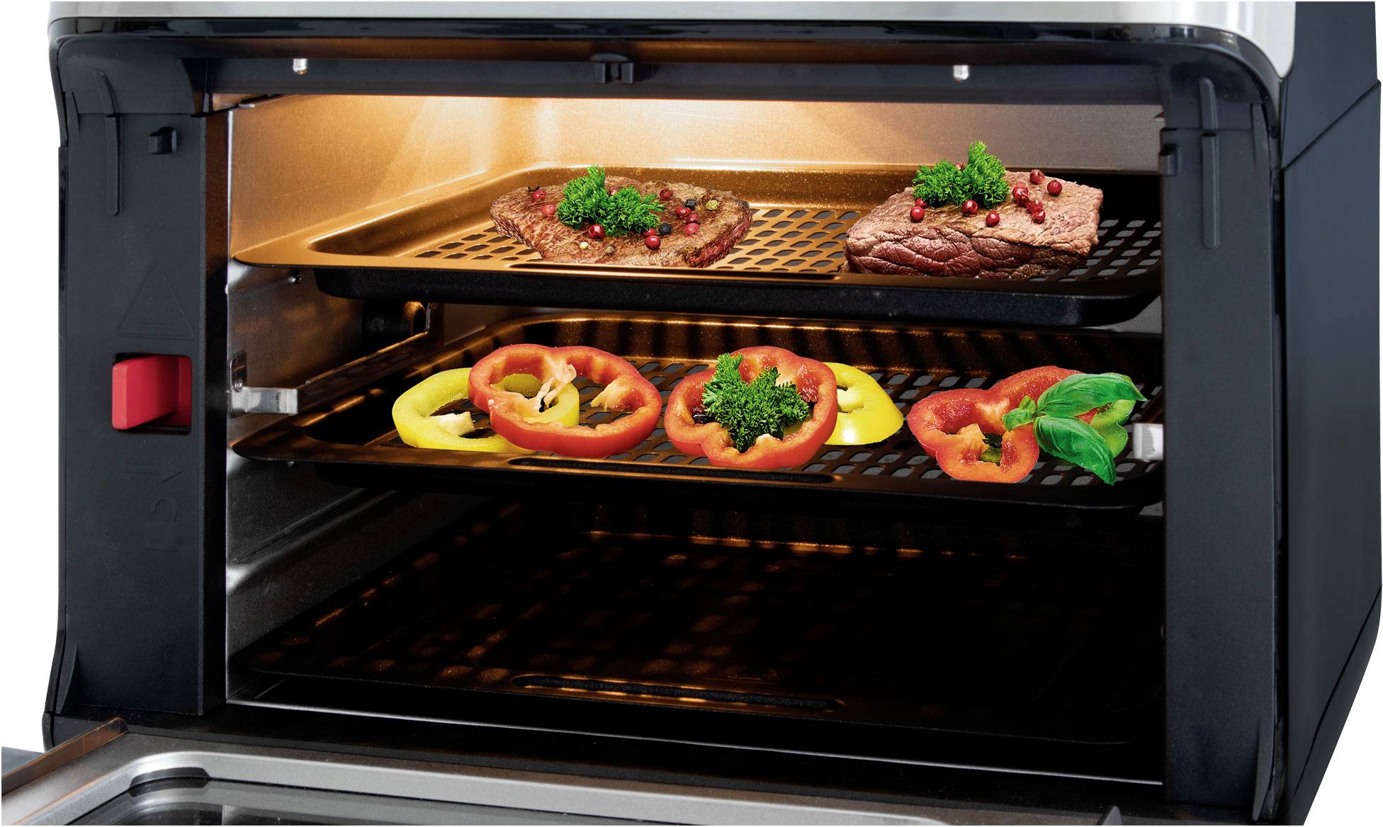Un forno aperto mostra due griglie con pietanze: in alto due pezzi di carne con erbe, in basso anelli colorati di peperone, anch'essi con erbe.