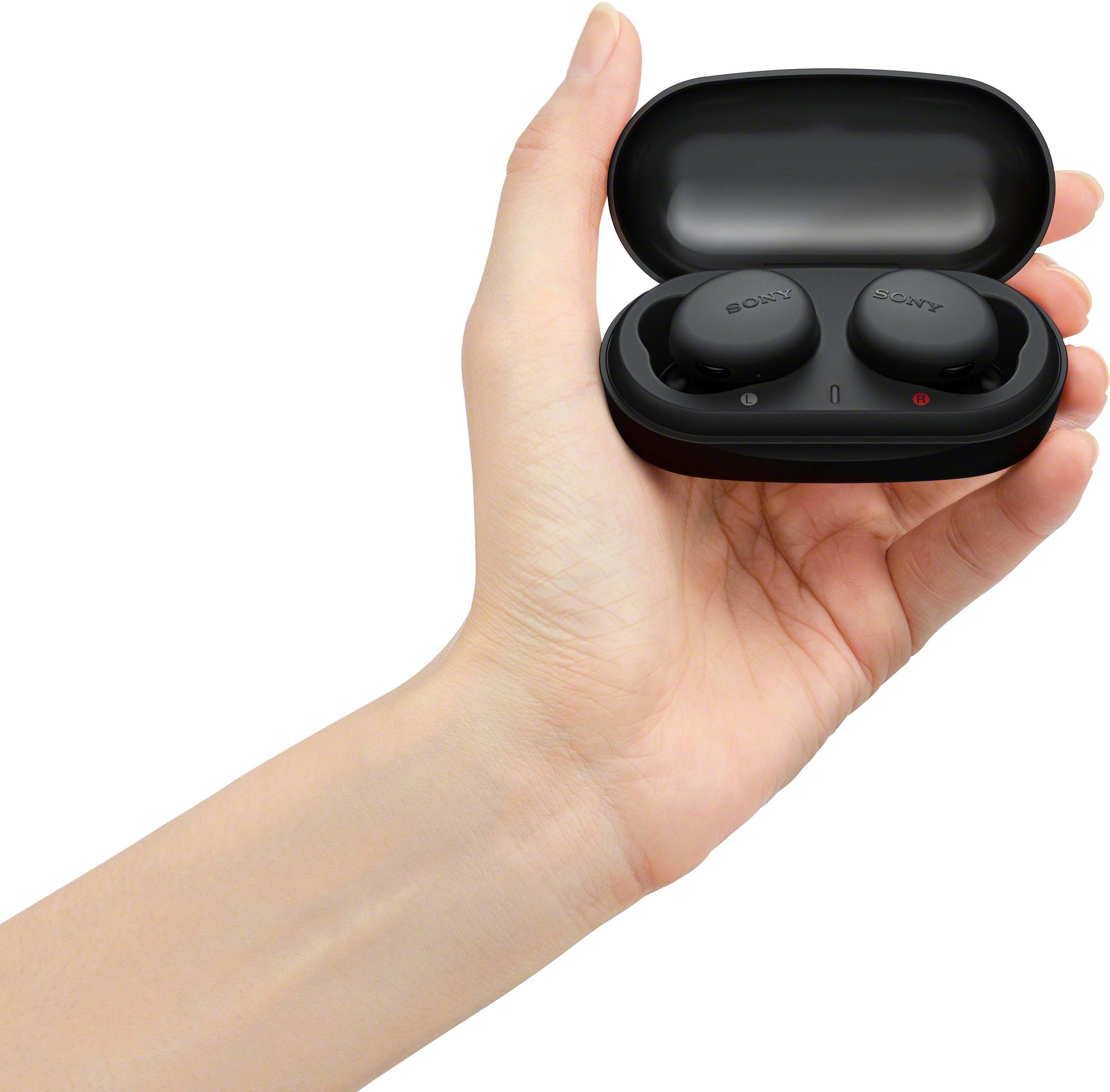 Una mano aperta tiene un astuccio nero con degli auricolari wireless al suo interno.