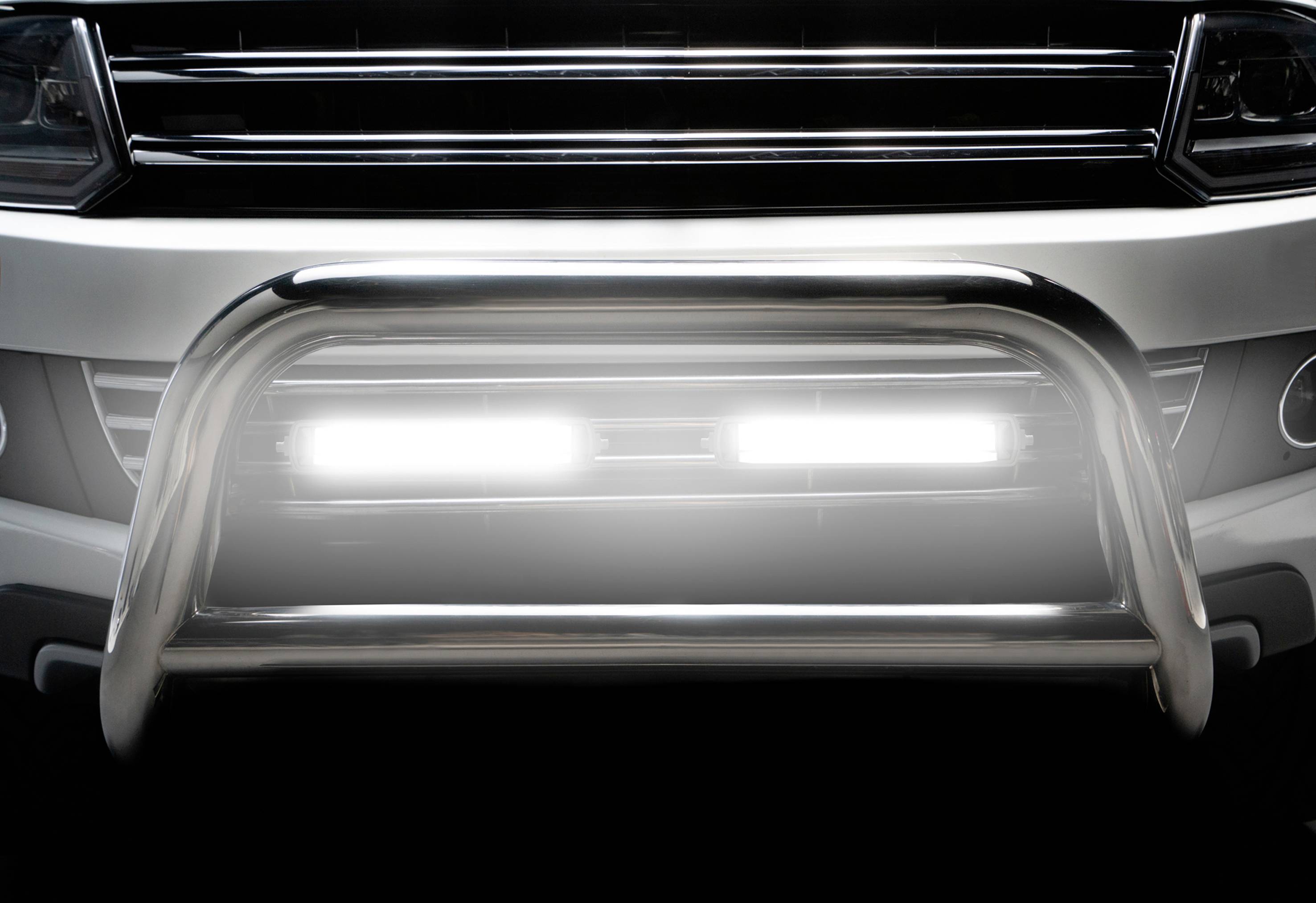 Vista frontale di un'auto con una robusta protezione sottoscocca e fari a LED che illuminano intensamente la parte anteriore.