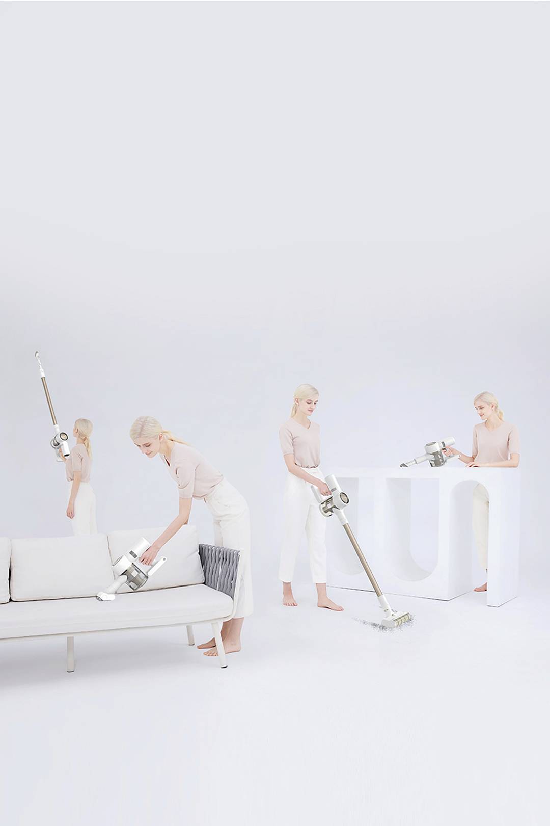 Persona che utilizza un aspirapolvere senza fili per svolgere diverse faccende domestiche: pulire il divano, aspirare il pavimento, spolverare il tavolo.