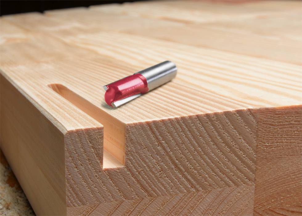Un pezzo di legno con una scanalatura, su cui è posizionata una testa fresatrice. La fresa viene utilizzata per la lavorazione del legno.