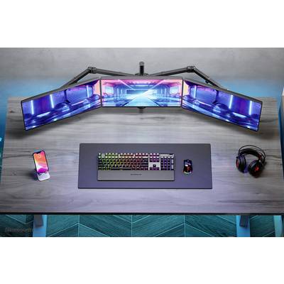 Una scrivania moderna con tastiera, mouse, smartphone, cuffie e tre monitor curvi che mostrano un'immagine futuristica blu e rosa.