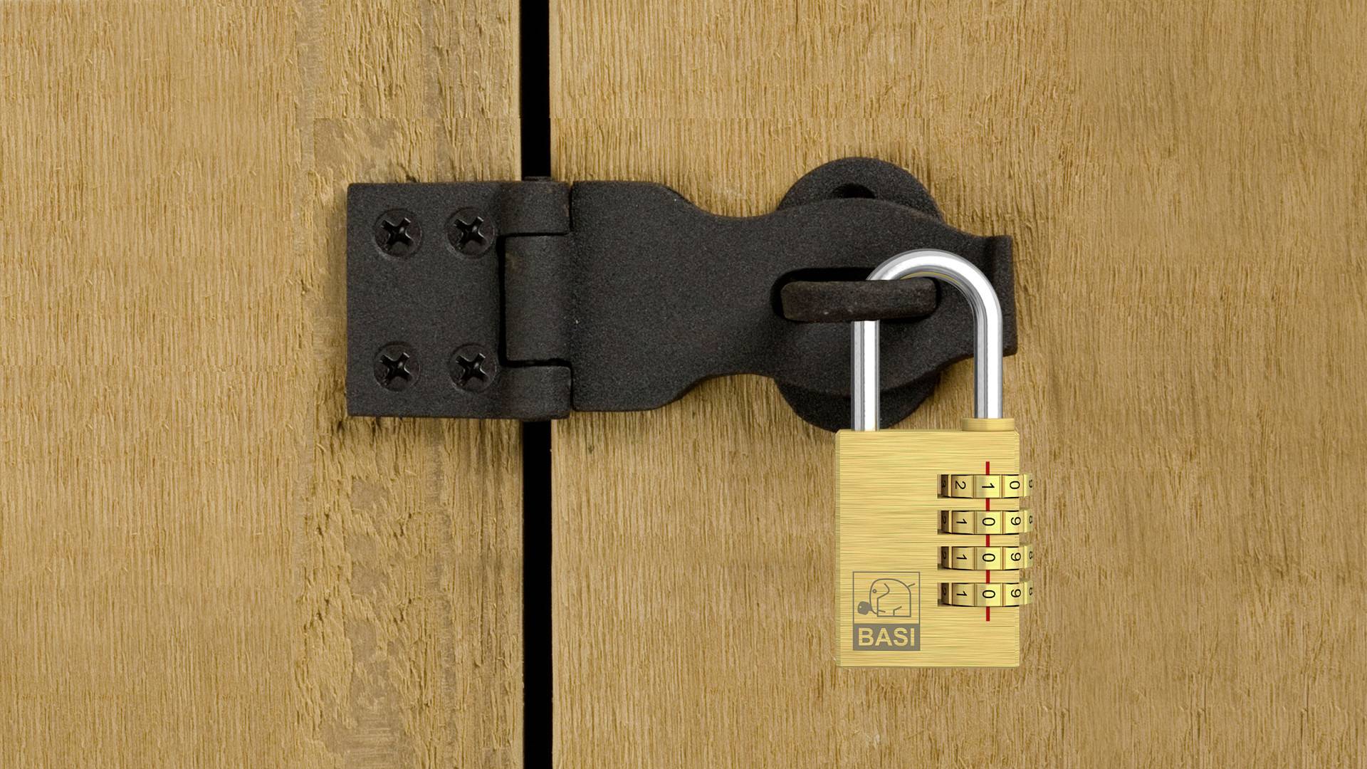 Un lucchetto con combinazione numerica che protegge una porta di legno. Il lucchetto è agganciato in una staffa metallica.