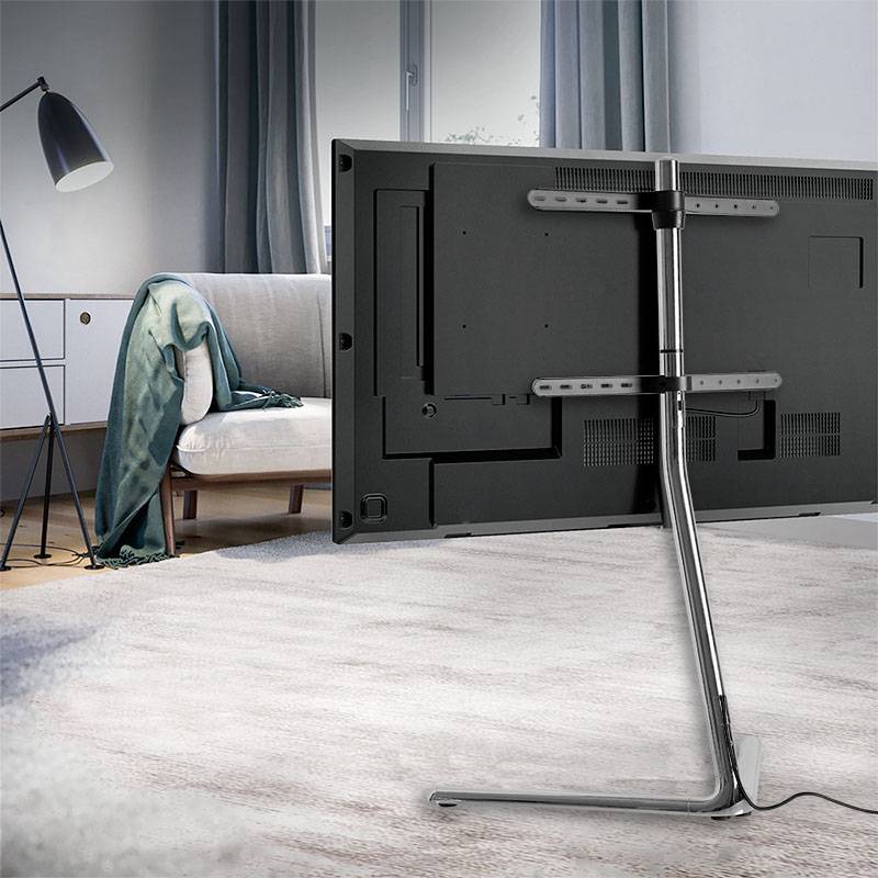 Un'area soggiorno elegante con un divano, una lampada da terra e un grande schermo TV montato su un supporto moderno.