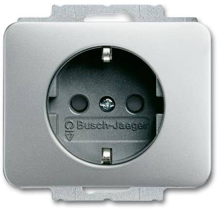 Una presa elettrica argentata della marca Busch-Jaeger con contatto di terra e cornice da esterno.