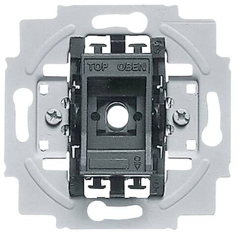 Cornice interruttore in metallo con inserto nero, punto centrale per il montaggio, scritta 'TOP SOPRA', simbolo direzionale per l'installazione.