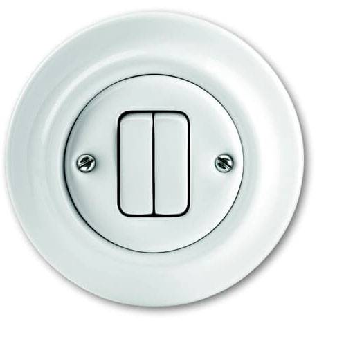 Un interruttore rotondo bianco con due interruttori a levetta, montato su una piastra bianca. Design piatto e minimale.