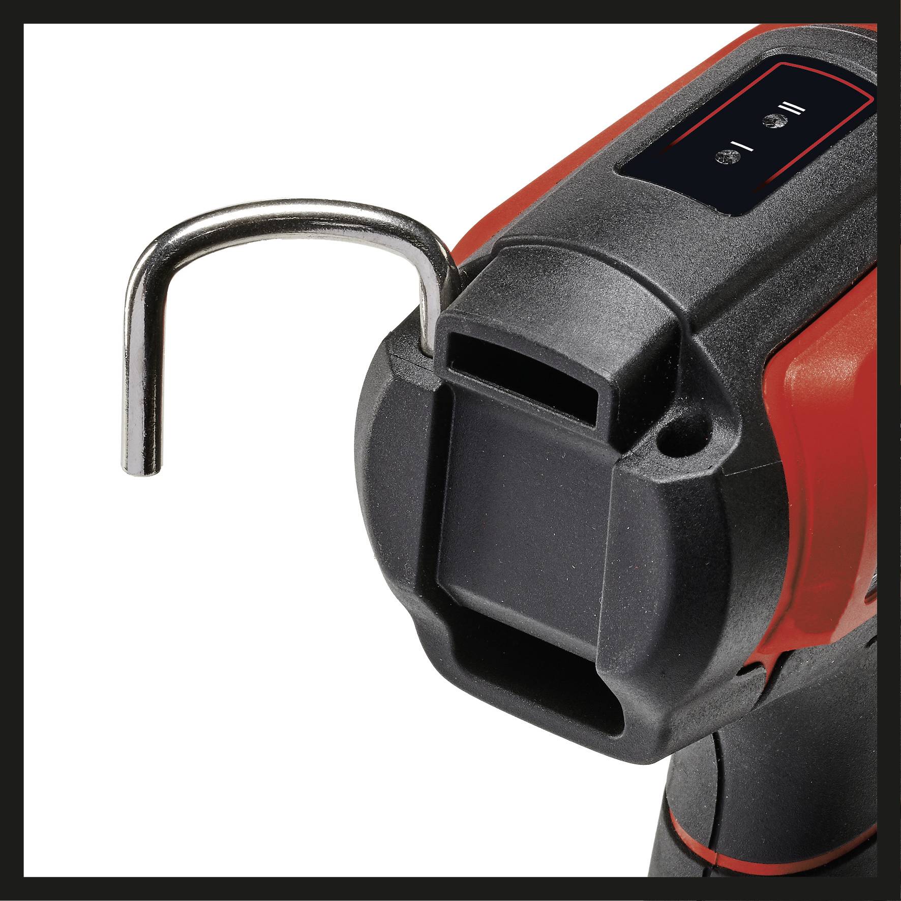 Un primo piano di un utensile elettrico nero e rosso, probabilmente un trapano a batteria, con un gancio sulla parte superiore.