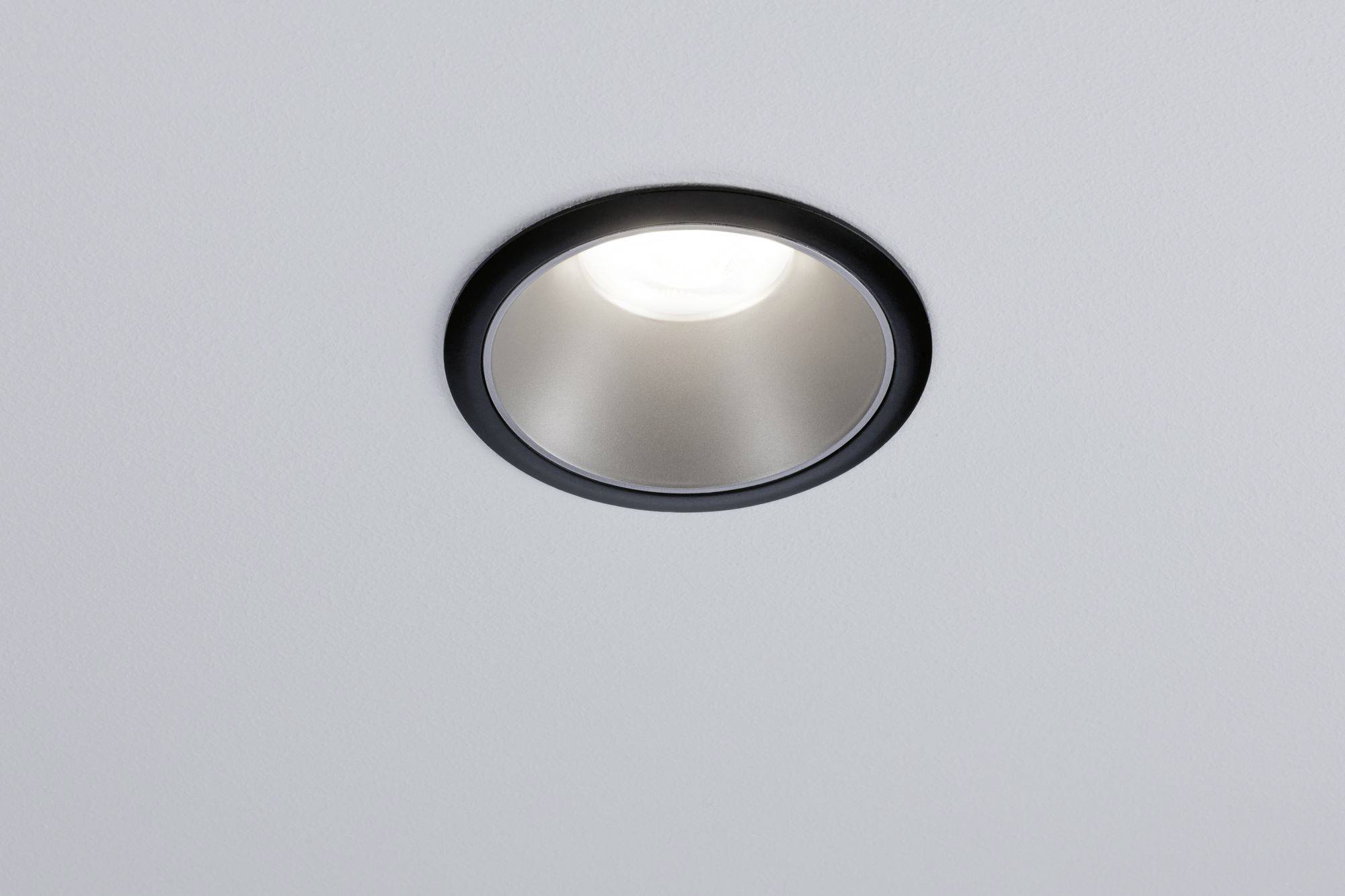 Una luce da incasso a soffitto illuminata su sfondo grigio.