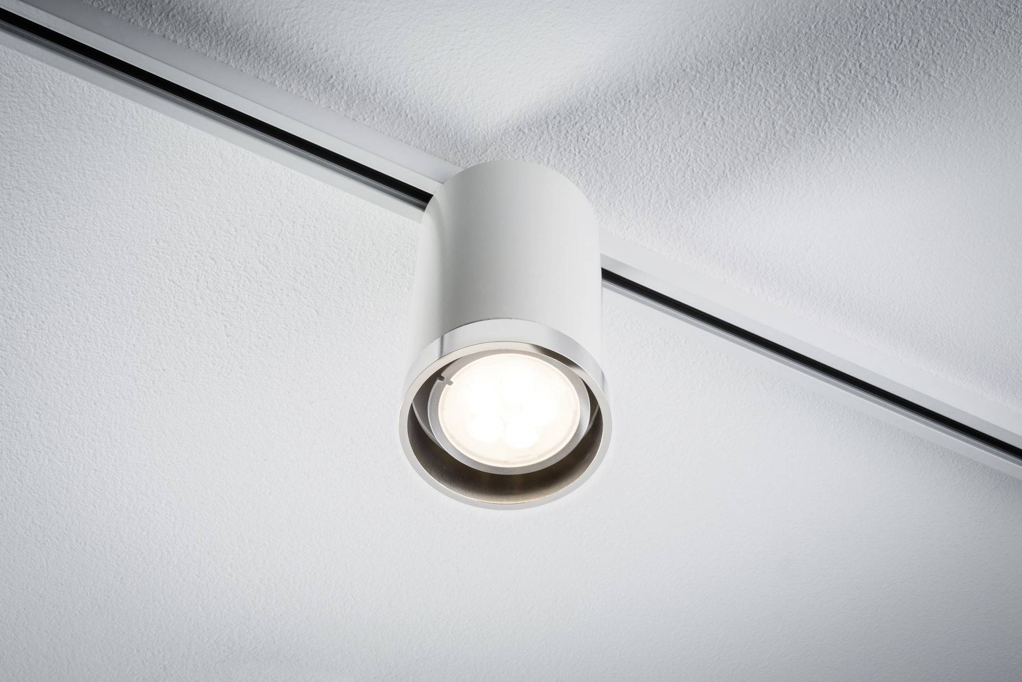 Plafoniera con design cilindrico moderno, illumina verso il basso su un soffitto bianco. Ideale per un'illuminazione mirata.