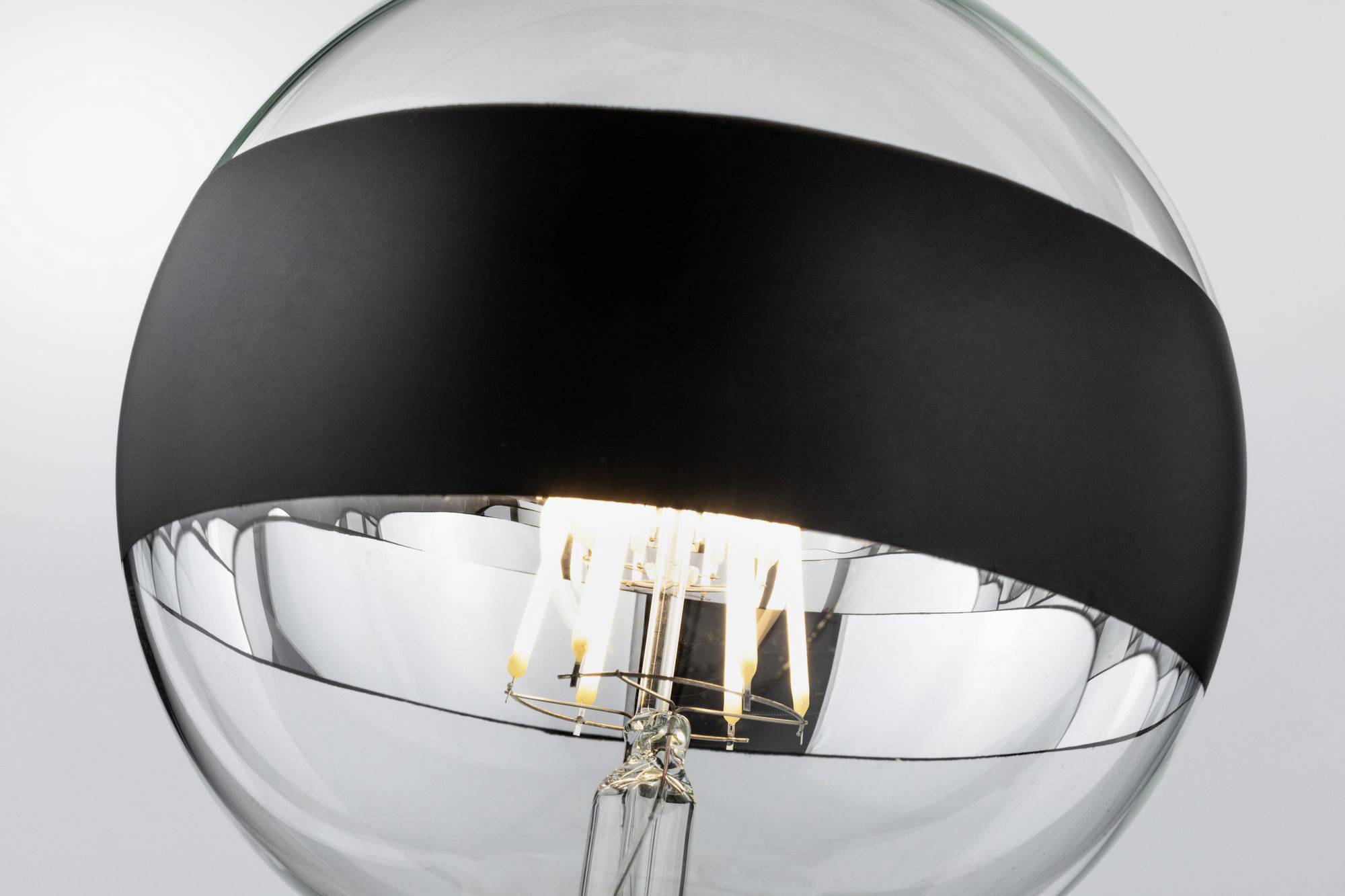 Lampadina in design moderno e trasparente con fascia nera. La lampada emana una luce calda e ha un aspetto elegante.