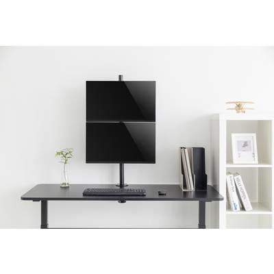 Un tavolo minimale con due monitor sovrapposti, una tastiera, un dispositivo mouse, un vaso con una pianta e scaffali per libri.