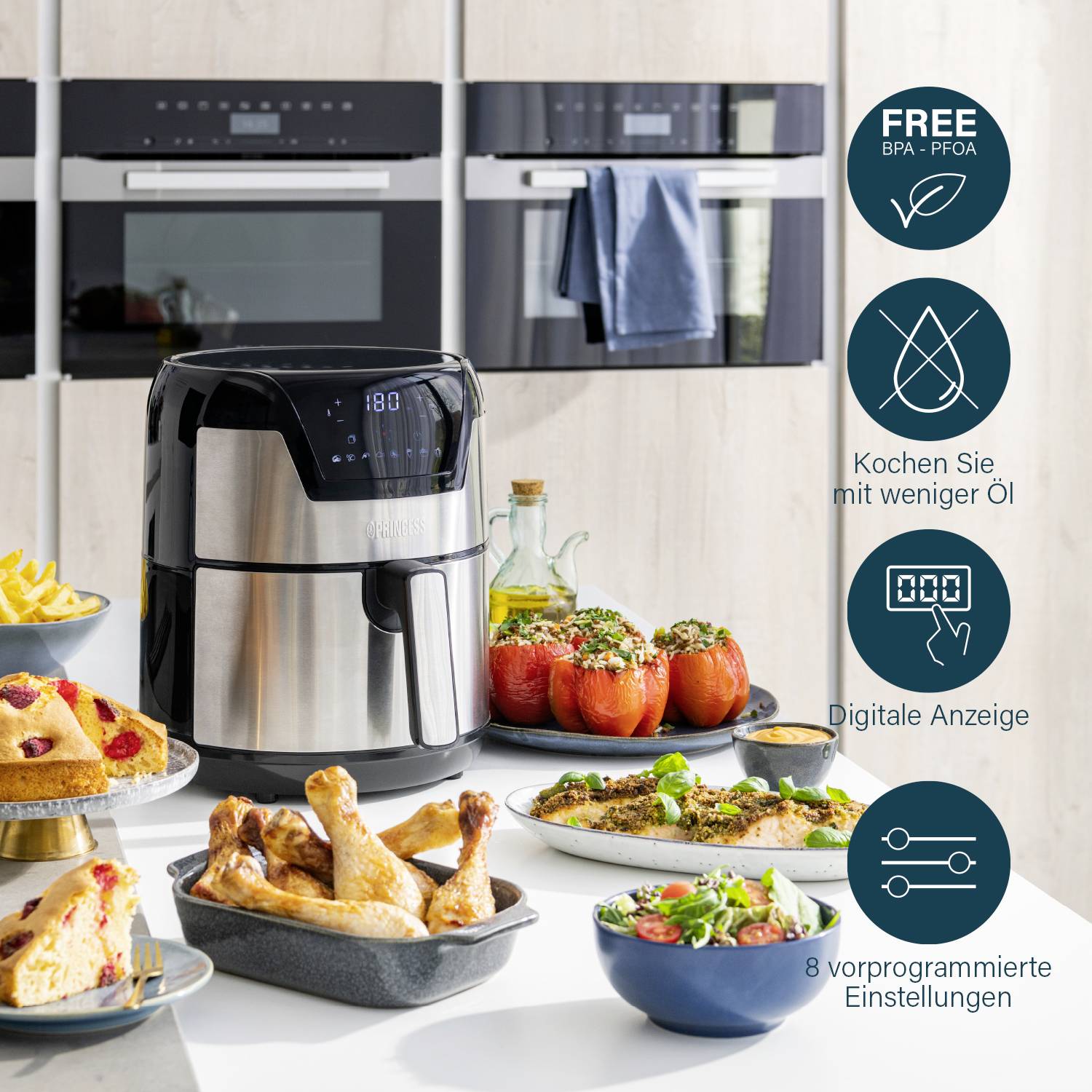 Un'air fryer su un tavolo con patatine fritte, pollo e pomodori ripieni. Accanto simboli: poco olio, display digitale, 8 programmi.