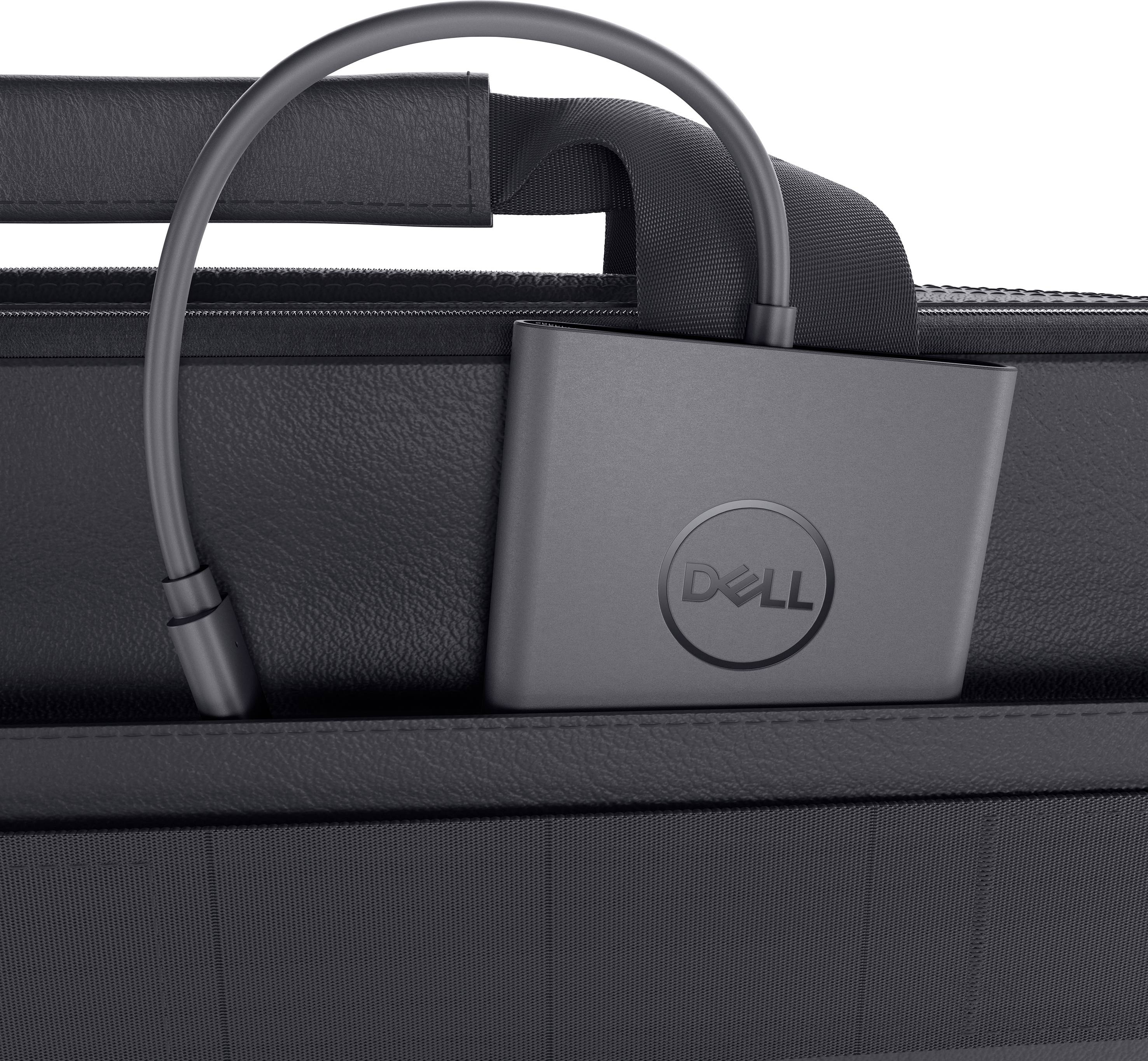 Un caricabatterie nero Dell è poggiato su una borsa per laptop nera. Il caricabatterie è parzialmente inserito nella presa.