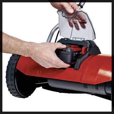 Una persona inserisce una batteria in un attrezzo da giardino elettrico rosso. Il dispositivo ha ruote grandi ed è presumibilmente un tagliaerba.