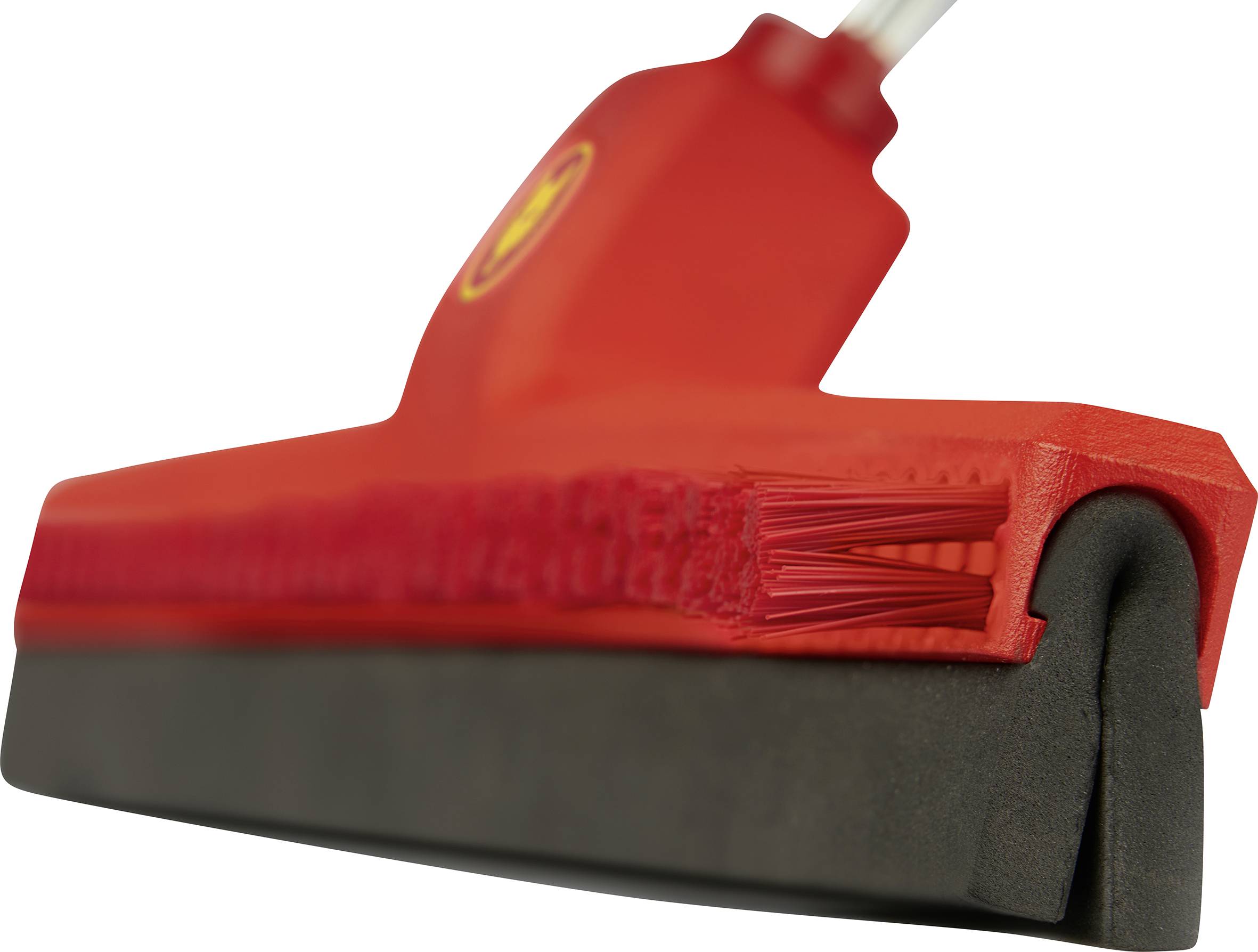Un pennello rosso con setole e bordo in gomma, ripreso da un angolo basso. Il focus è sulla struttura delle setole e del bordo.