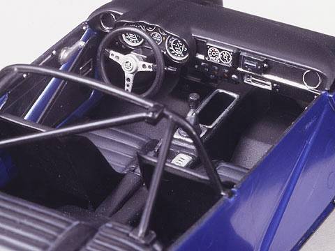 Vista interna di un modellino di auto blu con un cruscotto dettagliato, volante e sedili; mostra l'allestimento interno e la disposizione degli interni.