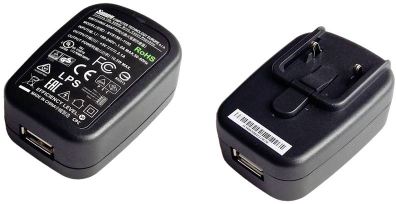 Due caricabatterie USB da parete neri con etichette tecniche e simboli sulla parte superiore, entrambi con spine pieghevoli.