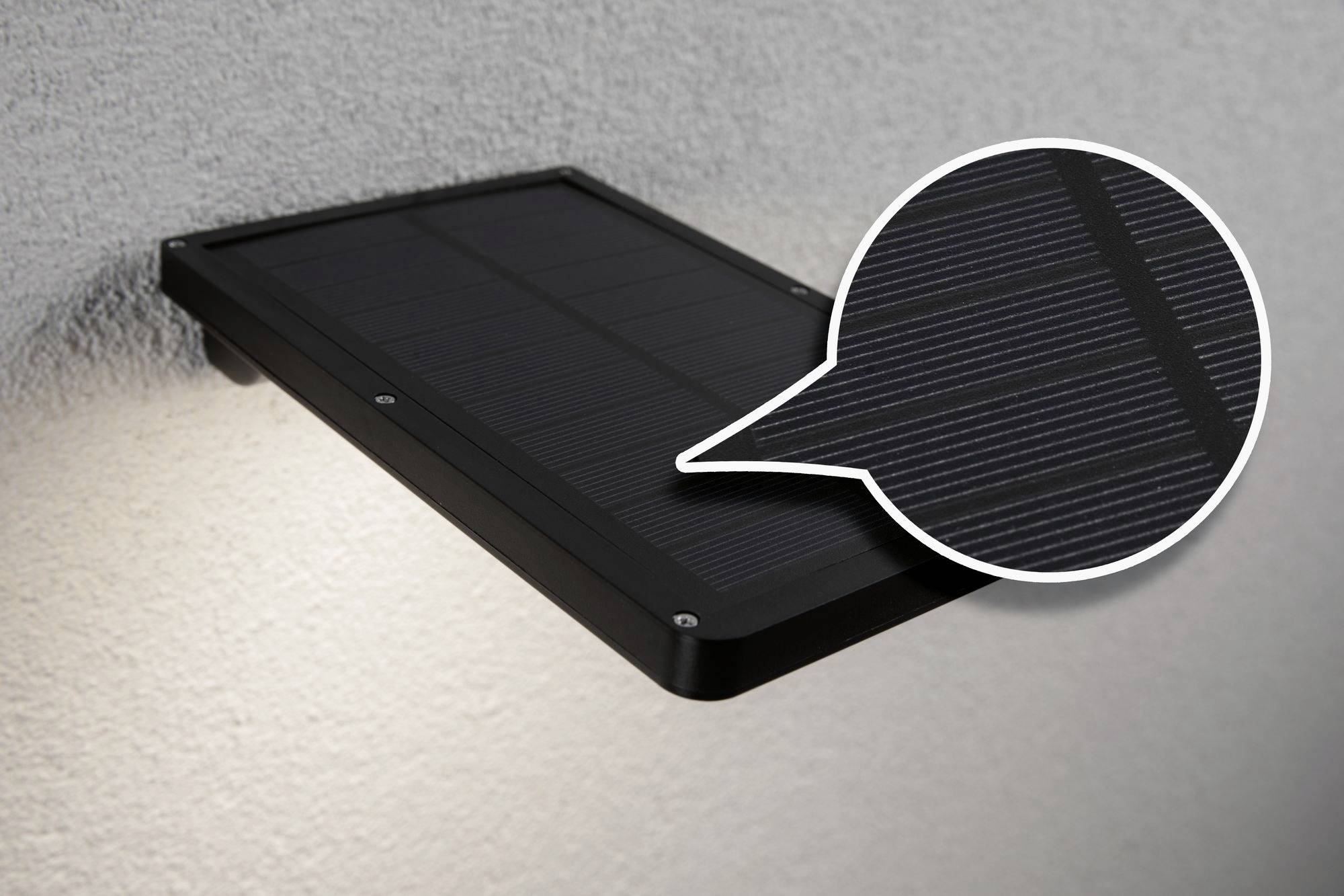 Modulo solare montato su una parete, con un effetto di ingrandimento sulla superficie delle celle solari.