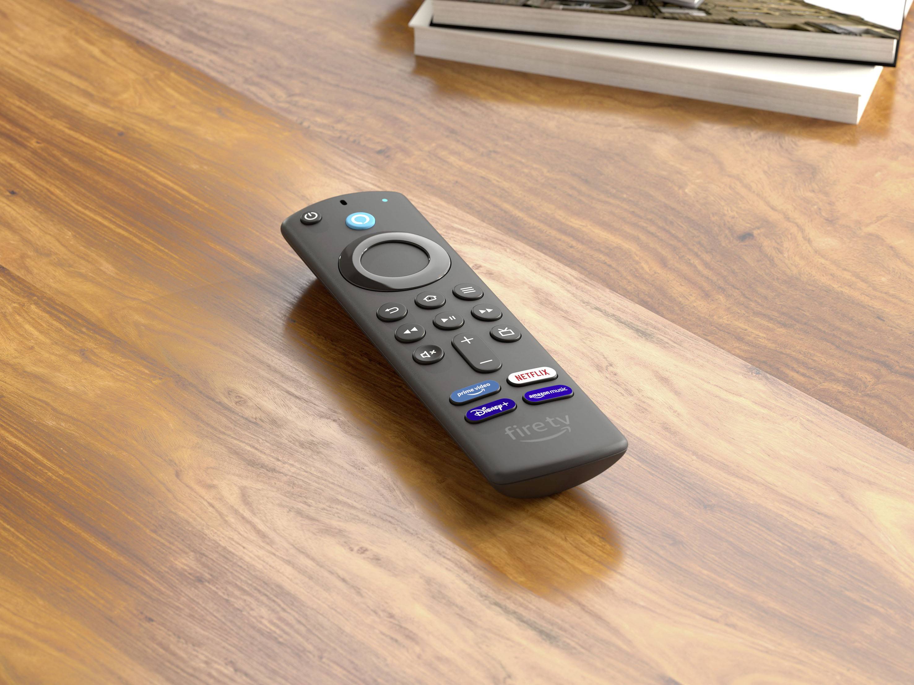 Un telecomando è posizionato su un tavolo di legno. Ha tasti per servizi di streaming come Netflix, Prime Video e Hulu. Sullo sfondo si vedono dei libri.