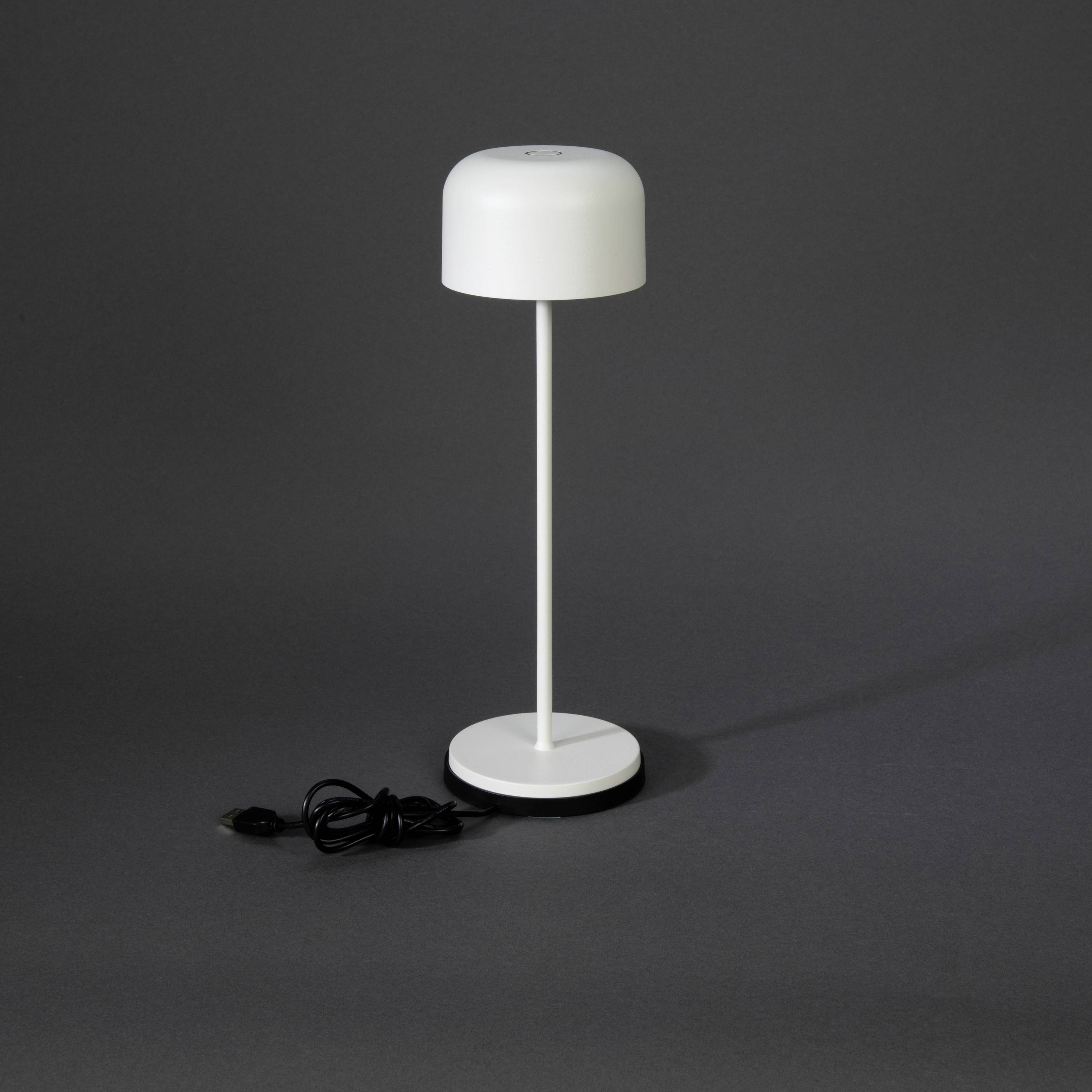 Una lampada da tavolo moderna con design semplice e bianco su sfondo grigio scuro. La lampada ha un aspetto rotondo e minimalista.