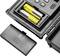 Vano batteria aperto con due batterie AA gialle in un dispositivo elettronico, accanto a un coperchio nero rimosso.