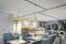 Moderna hall di accoglienza con scritta 'Welcome' sulla parete, sedie imbottite blu, bancone in legno e piante per un'atmosfera accogliente.