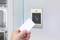 Una mano tiene una carta di accesso bianca davanti a un lettore di schede su una porta, pronta per essere scansionata. Lo spazio sullo sfondo è parzialmente visibile.