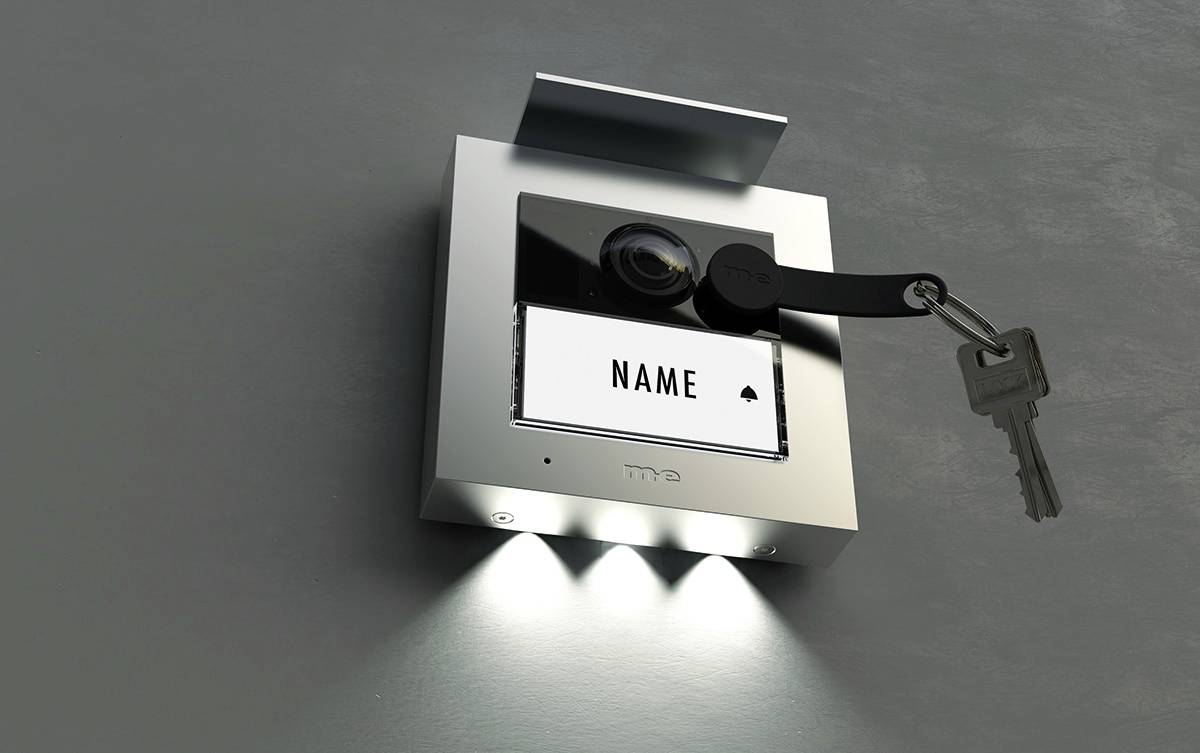 Interruttore a chiave su una parete con due LED illuminati. Una chiave è inserita nella serratura, e sotto è scritto 'NOME'.