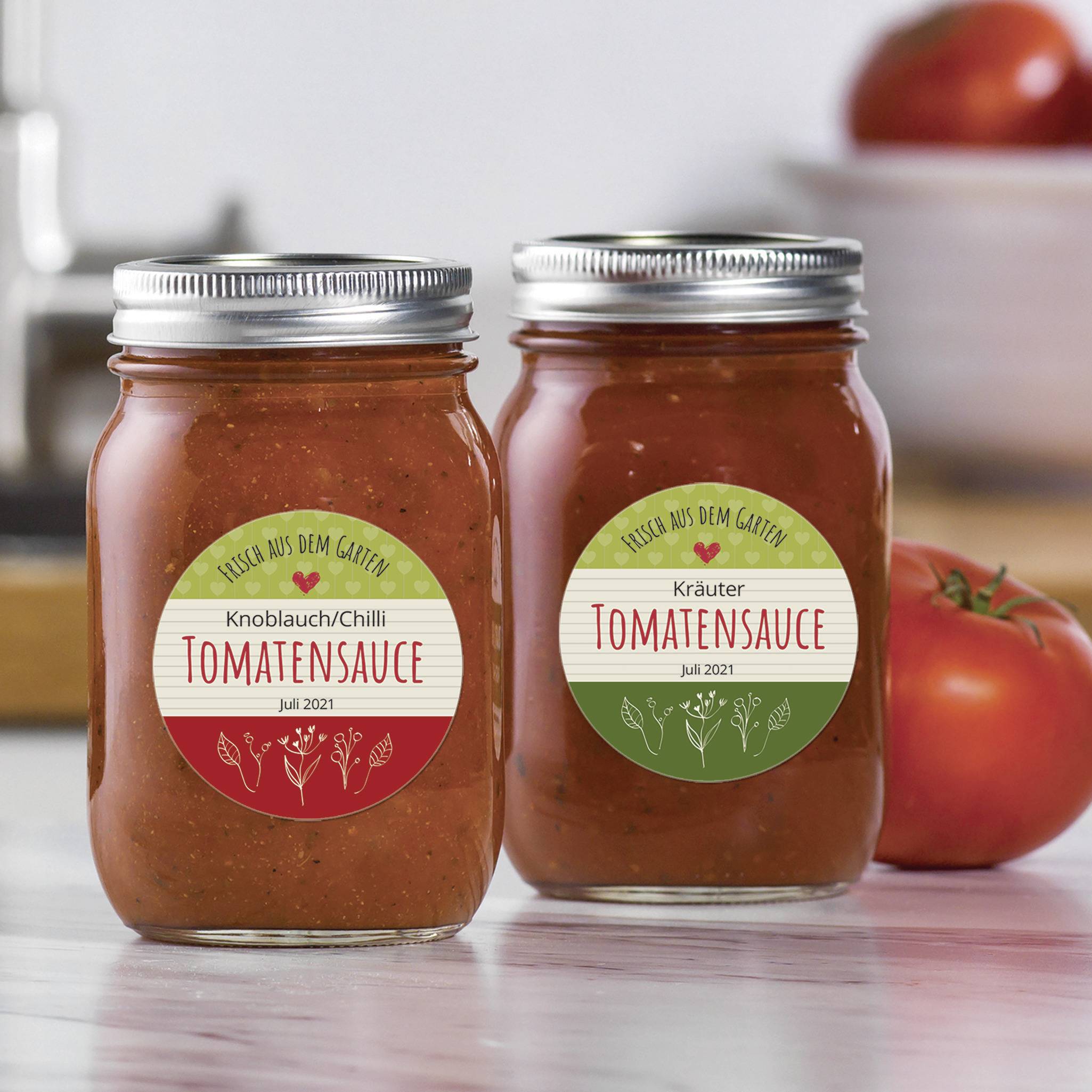 Due vasetti di sugo di pomodoro su un tavolo, ciascuno con un'etichetta rossa e verde. Sullo sfondo un pomodoro e utensili da cucina.
