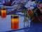 Candele su una lapide con un arrangement floreale sullo sfondo, che creano un'atmosfera di ricordo e commemorazione.