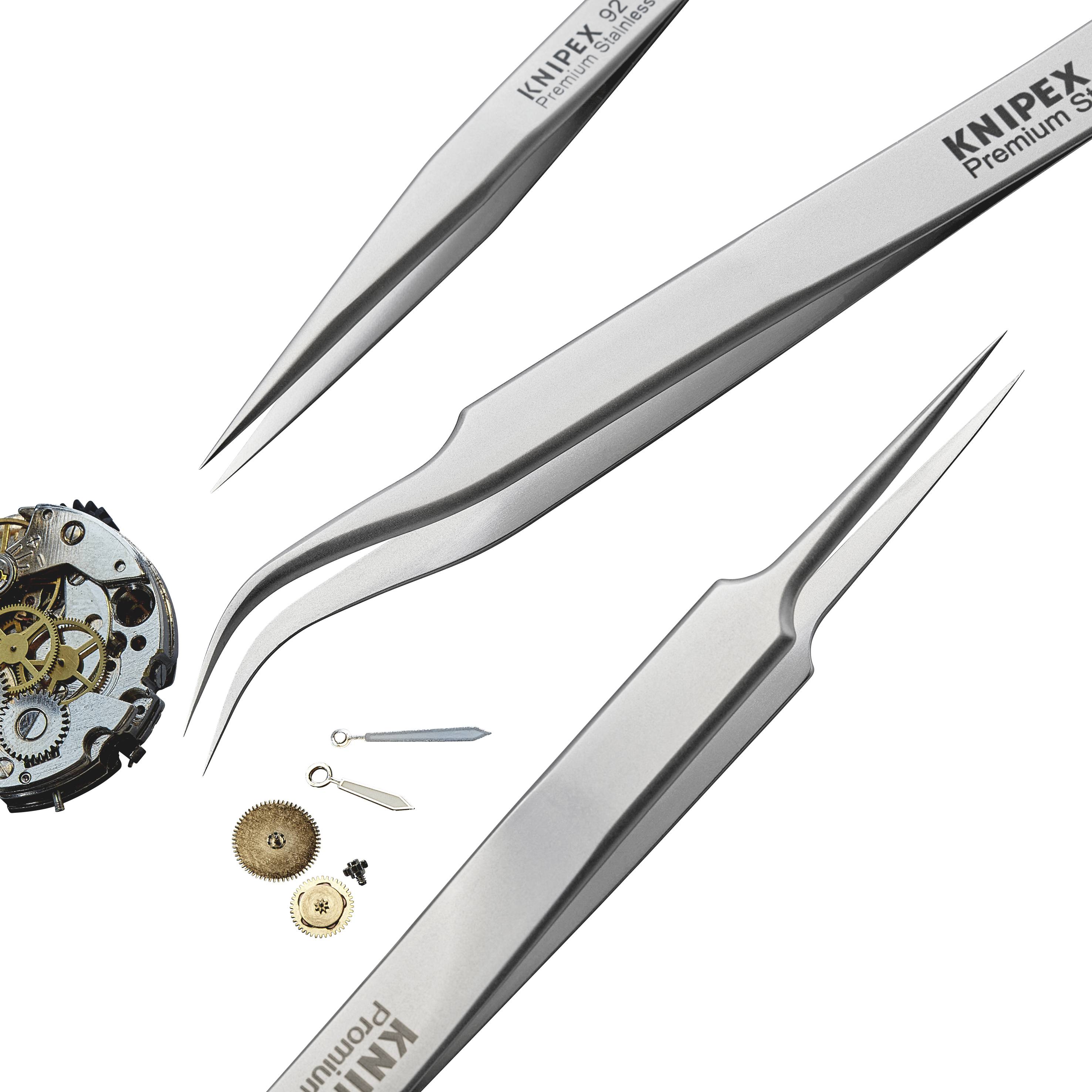 Utensili di meccanica di precisione circondano un movimento con ingranaggi e molle.