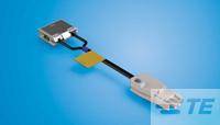 Un componente elettronico argentato con due cavi su uno sfondo blu. Sembra appartenere a un dispositivo tecnico.