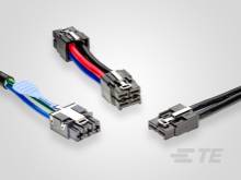Tre diversi cavi di dati con guaine colorate e connettori sono adagiati su uno sfondo bianco. Simboleggiano la connettività.