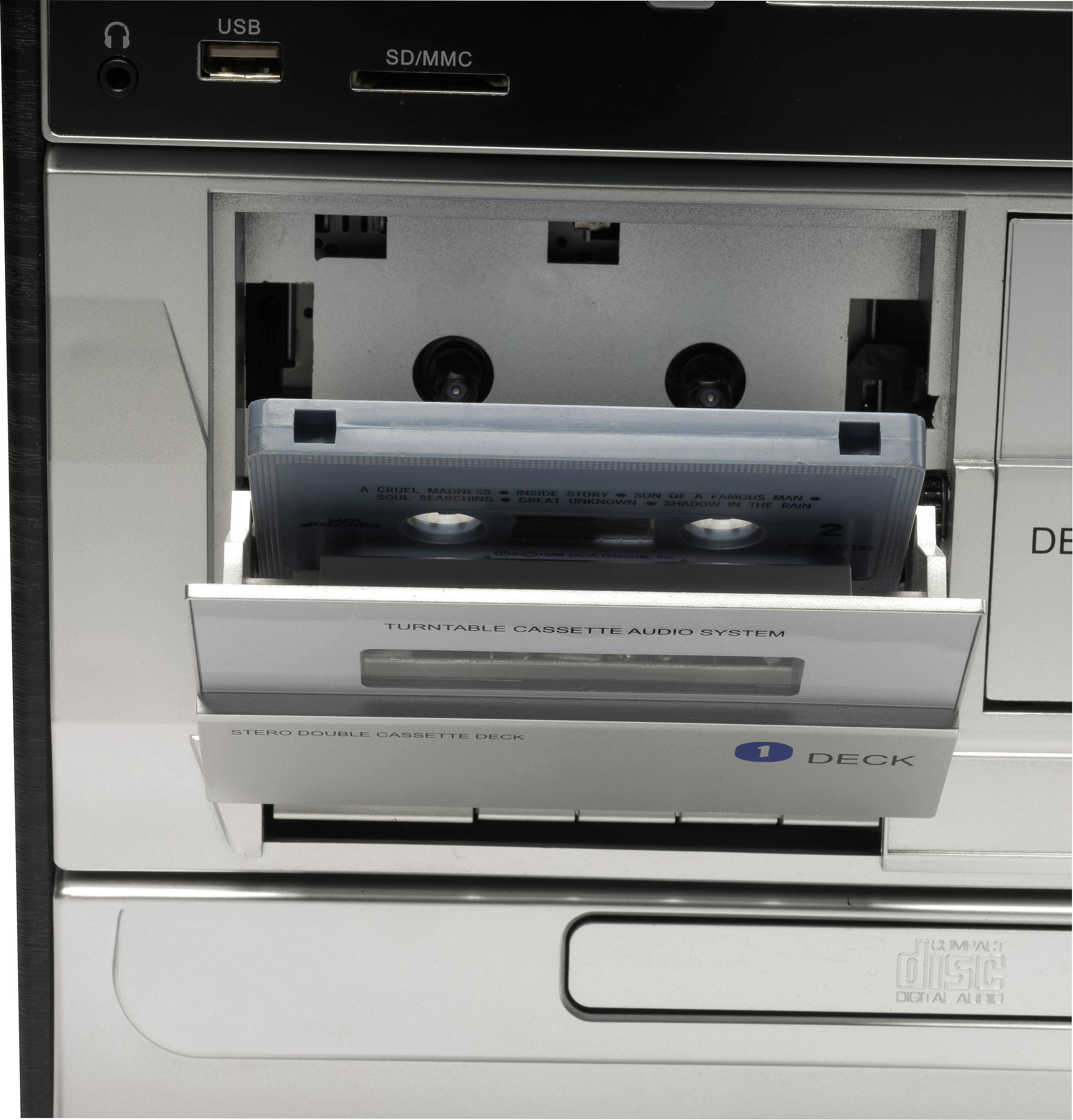 Una cassetta viene inserita in un deck di un sistema audio. In alto sono presenti porte USB e slot SD/MMC.