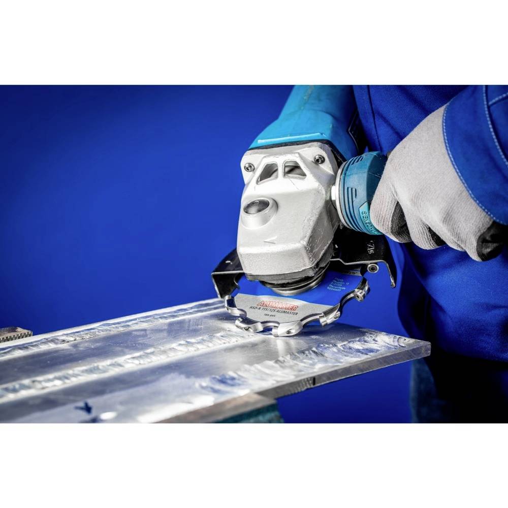 Una persona sta utilizzando un smerigliatrice angolare per tagliare il metallo. La persona indossa abiti da lavoro blu e guanti di protezione.